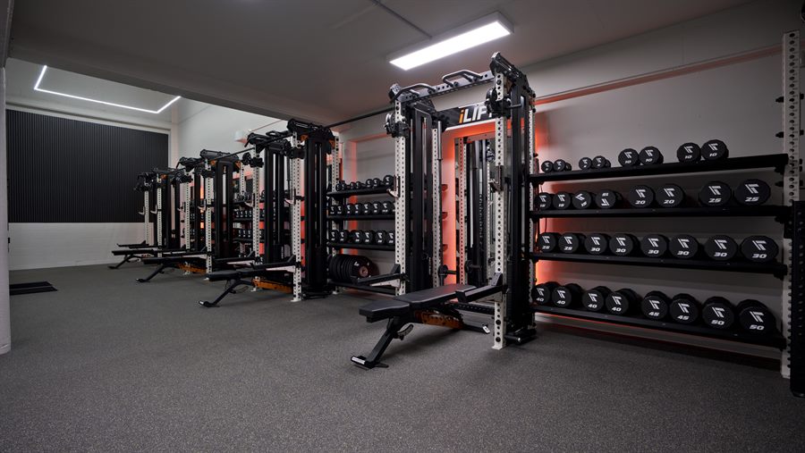 RECON gym fitout with strength racks and red accent lighting